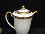 a white and gold tea pot with a gold lid