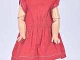 une image représentant une poupée vêtue d'une robe rouge et d'un chapeau de paille