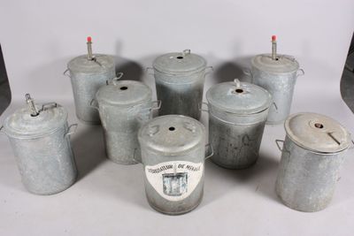 several old tin cans are lined up on a white surface