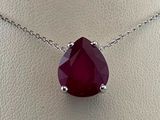 un gros plan d'un collier orné d'une pierre rouge sur un mannequin