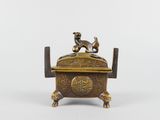 an antique brass box with a dog sitting on top of it