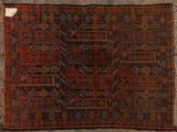 an old rug with fringes on a wooden floor next to a wall