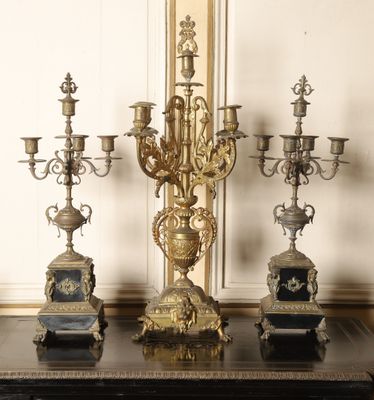 three ornate candelabs sitting on a table in a room