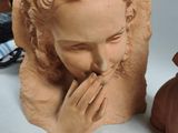a statue of a woman holding her hands to her face