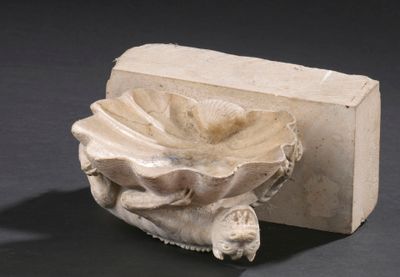 un objet en pierre orné d'une fleur, posé à côté d'un morceau de savon
