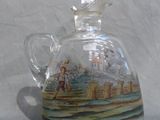 a glass bottle with a picture on it on a table