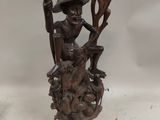 a statue of a man sitting on top of a tree