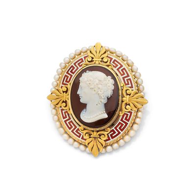 une image représentant une broche rouge et dorée en forme de tête de femme