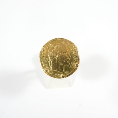 une pièce d'or posée sur une surface blanche