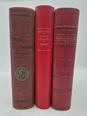 three red books sitting on top of each other on a white surface