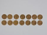 plusieurs pièces d'or sont disposées en ligne sur une surface blanche