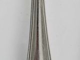 a silver spoon with a handle on a white table