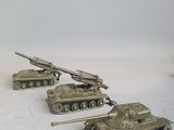 four small toy tanks sitting on a white surface
