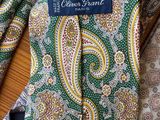 green and yellow paisley necktie with a blue label on it