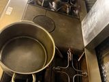 pots and pans on a stove in a kitchen with tiled floor