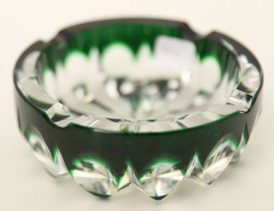 un cendrier en verre vert et noir posé sur une table