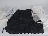 une robe noire et une paire de chaussures blanches posées sur une table