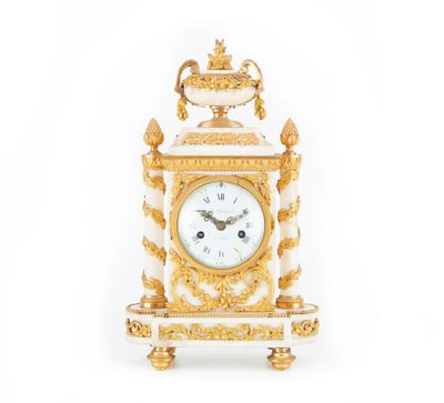 une horloge dorée et blanche posée sur une table
