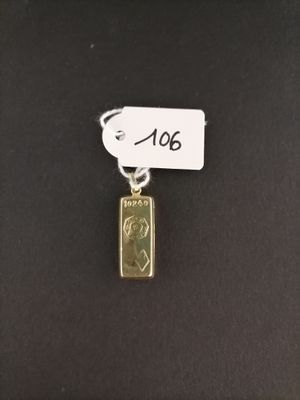 a gold plated pendant with a small piece of gold on it