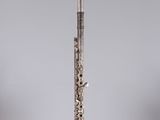 the flute is sitting on a clear stand on a white surface