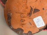 a person holding a piece of clay with a tag on it