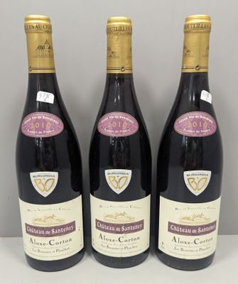 trois bouteilles de vin sont alignées sur une table