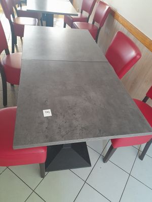 une longue table avec des chaises rouges au milieu de la pièce