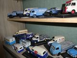 de nombreuses petites voitures et camions sur une étagère dans une pièce