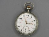a silver pocket watch on a gray surface