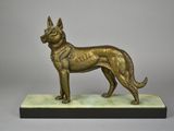 statue en bronze représentant un chien, posée sur un socle en marbre, sur fond gris