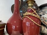three vases sitting on a shelf with a clock in the background