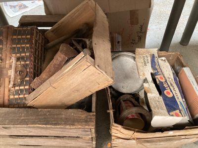 une boîte remplie de vieux livres et d'autres objets, posée par terre