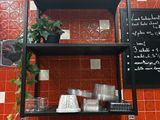 a red tiled wall with a black shelf above it