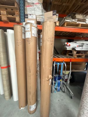 Plusieurs rouleaux de papier sont empilés les uns sur les autres dans un entrepôt
