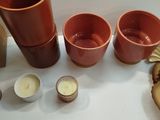 three cups, a candle, and a mushroom on a table