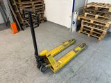 un chariot élévateur jaune avec des palettes en arrière-plan