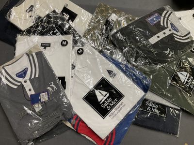 de nombreux t-shirts emballés dans du plastique, posés sur une table