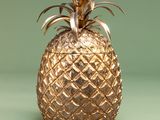 a gold pineapple sitting on a green surface