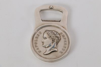 une image représentant un décapsuleur en forme de pièce de monnaie sur lequel figure le visage d'une femme
