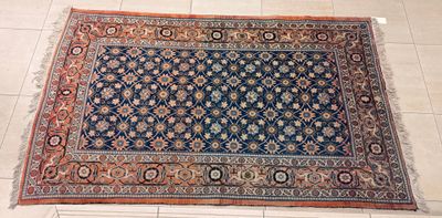 un tapis oriental posé à même le sol dans une pièce carrelée