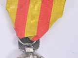 a silver medal with a red and yellow ribbon on it