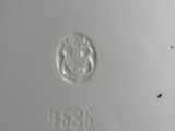 an image of a close up of a white plate with a crest on it