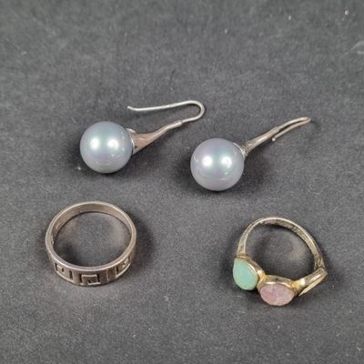 trois bagues et une paire de boucles d'oreilles sont posées sur une table