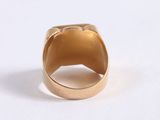 an image of a gold ring sitting on top of a white surface