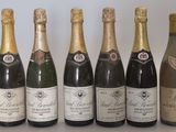 six bouteilles de champagne sont alignées sur une table