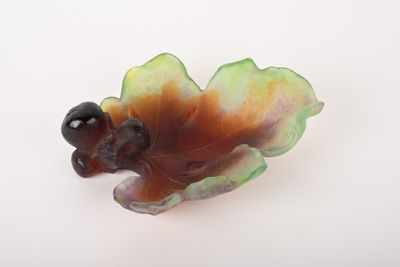 une figurine représentant un oiseau perché sur une feuille