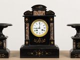 trois horloges noires et dorées posées sur une table