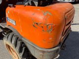 an orange tractor that is parked in the parking lot