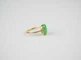 a gold ring with a green stone in the middle