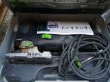a box with a corded sander and a tool in it